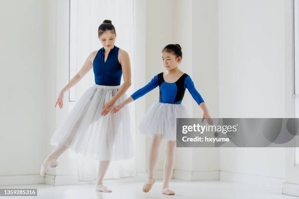 young girl practicing ballet dance with her instructor - gymnastic asian stockfoto's en -beelden
