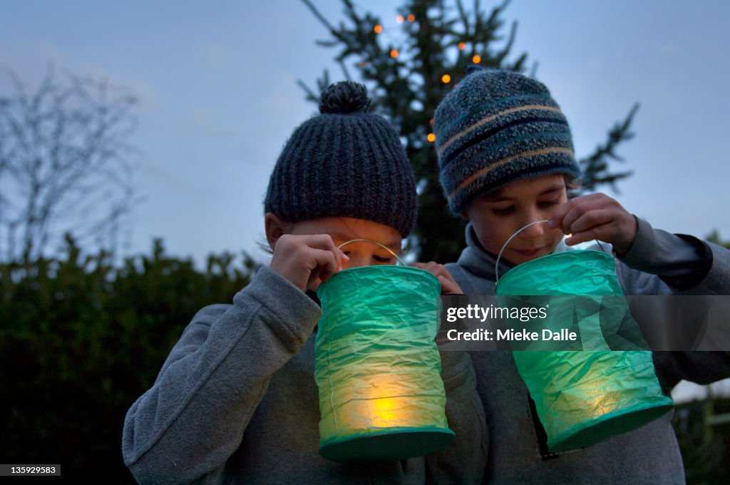 Boys holding lanterns in the dark