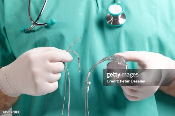 surgeon holding heart pacemaker - medical equipment stock pictures, royalty-free photos & images