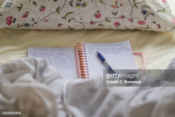 diary notebook on the sheets of a bed - diary stock-fotos und bilder