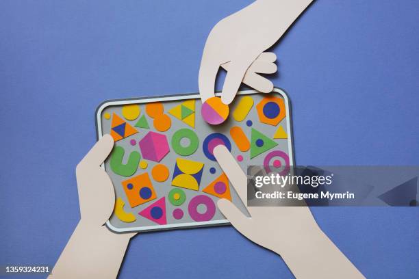 hands holding digital tablet with multi colored geometric shapes - app development stock pictures, royalty-free photos & images