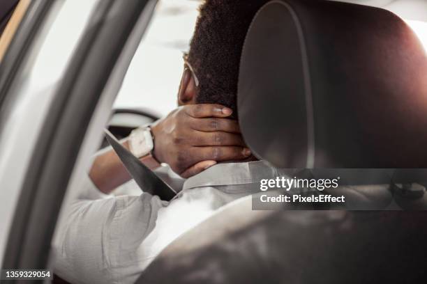 man having neck pain while driving a car - neck pain stock pictures, royalty-free photos & images