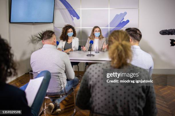 at press room, female epidemiologists talking about new sars-cov-2 omicron variant, and how to prevent the illness - live event covid stock pictures, royalty-free photos & images