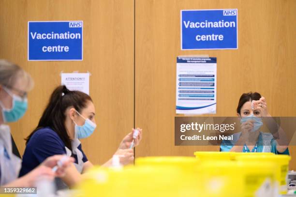 Medical staff and volunteers prepare shots of the Moderna vaccine at an NHS Covid-19 vaccination centre on December 16, 2021 near Ramsgate, United...