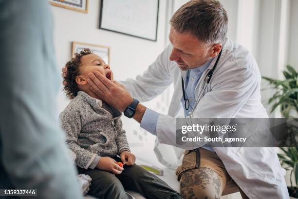 little boy at the pediatrician - throat exam stock pictures, royalty-free photos & images