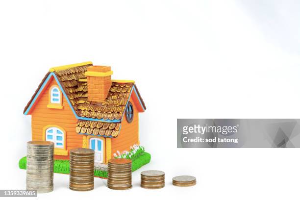 house model with coins on white background - gold loan stock pictures, royalty-free photos & images
