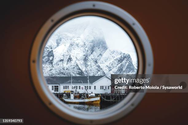 rorbu and snowy mountains view from ferry, norway - hublot photos et images de collection