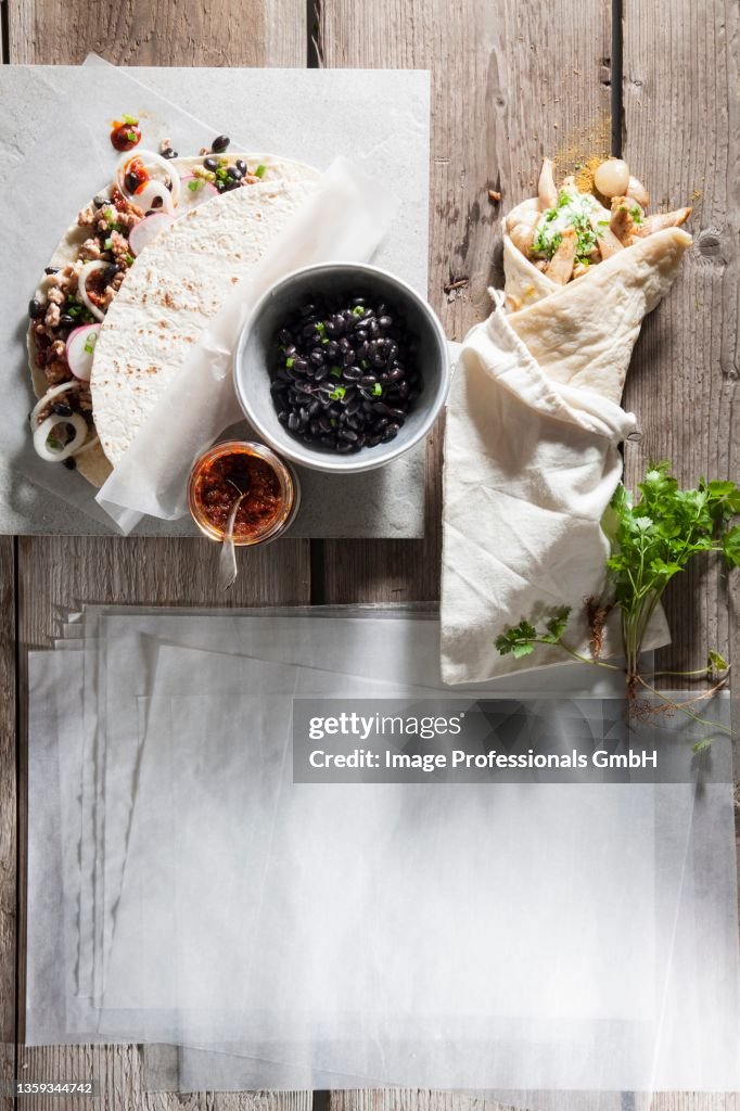 Tortilla wraps with minced turkey and beans next to Shawarma with green tahini