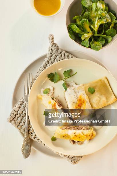 mushroom-filled ravioli topped with melted parmesan, served with lamb's lettuce - maultaschen stock-fotos und bilder