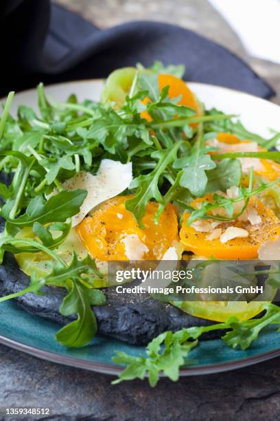 black pizza with activated charcoal, green and yellow tomatoes, parmesan cheese and rocket - shaved parmesan stock pictures, royalty-free photos & images