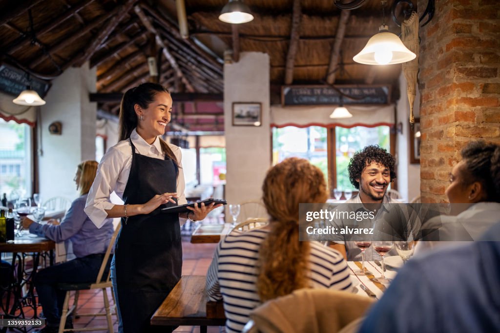 Restaurant waitress taking lunch order from guests