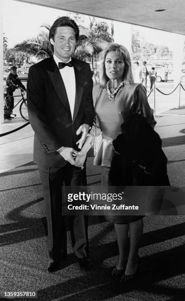 American actor Bruce Boxleitner, wearing a tuxedo and bow tie with a white shirt, and his wife, American actress Kathryn Holcomb, attend an event,...