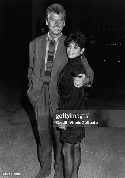 American actor Barry Bostwick, wearing a suit with a horizontally-striped tie, with his arm around his wife, American actress Stacey Nelkin, wearing...