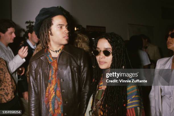 American singer-songwriter and musician Lenny Kravitz, wearing a brown leather jacket and a scarf, and American actress Lisa Bonet , wearing...