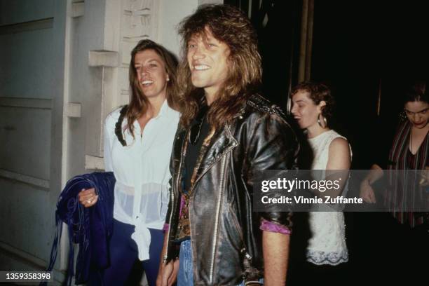 American singer, songwriter and guitarist Jon Bon Jovi, wearing a black leather jacket with the sleeves rolled up, alongside his wife, Dorothea, who...