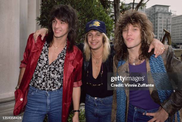 American guitarist Richie Sambora, wearing a red jacket over a black-and-white shirt, American rock singer Vince Neil, and American singer,...