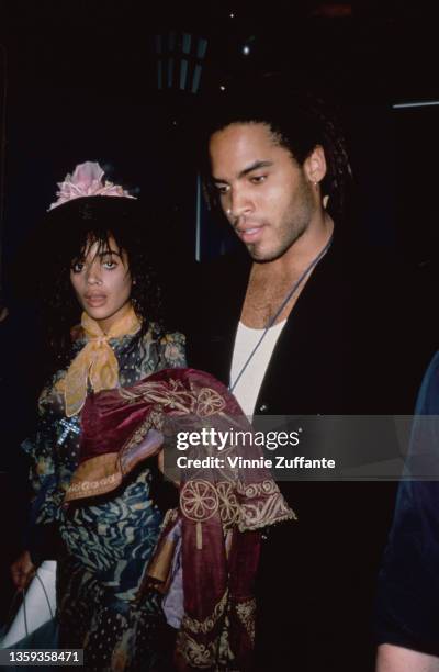 American actress Lisa Bonet , wearing a yellow scarf, with her husband, American singer-songwriter and musician Lenny Kravitz, wearing a black jacket...