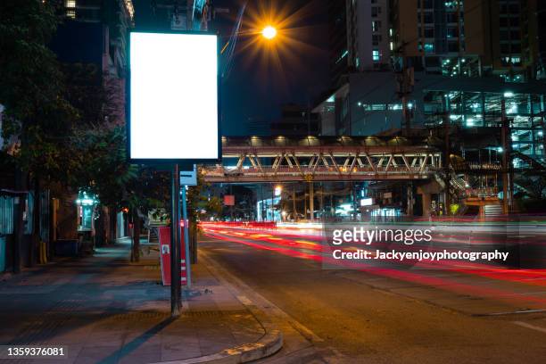 blank billboard on city street at night. outdoor advertising - billboard highway stock-fotos und bilder