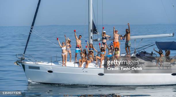 group of friends waving and enjoying  sailing - yacht party stock pictures, royalty-free photos & images