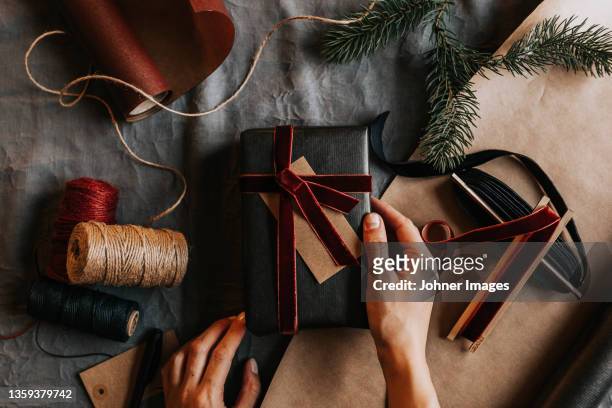 high angle view of womans hands holding wrapped present - johner christmas bildbanksfoton och bilder