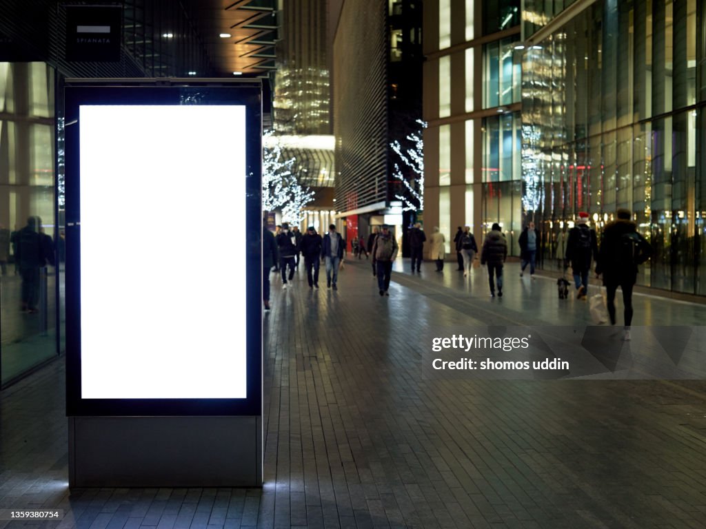 Empty digital billboard on busy street in London at night