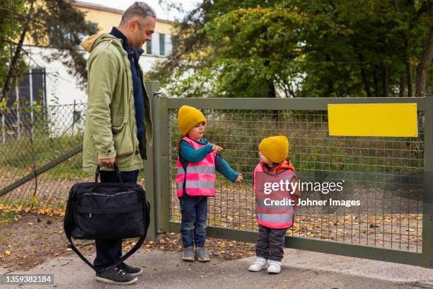 father collecting children from school - apporteren stockfoto's en -beelden