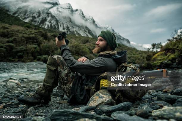 hunter in mountains looking at view - camping equipment stock pictures, royalty-free photos & images