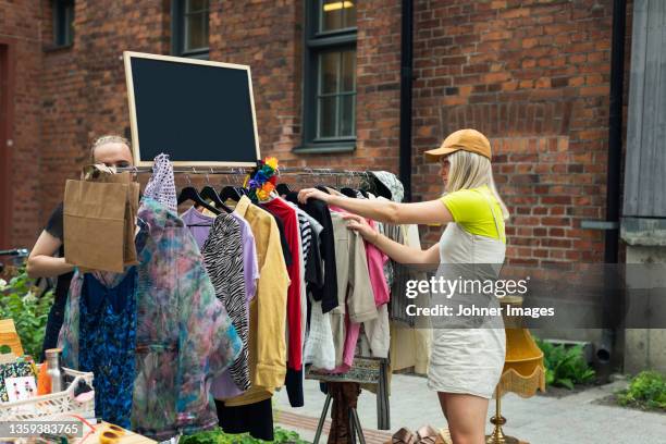 young woman at yard sale - rommelmarkt stockfoto's en -beelden