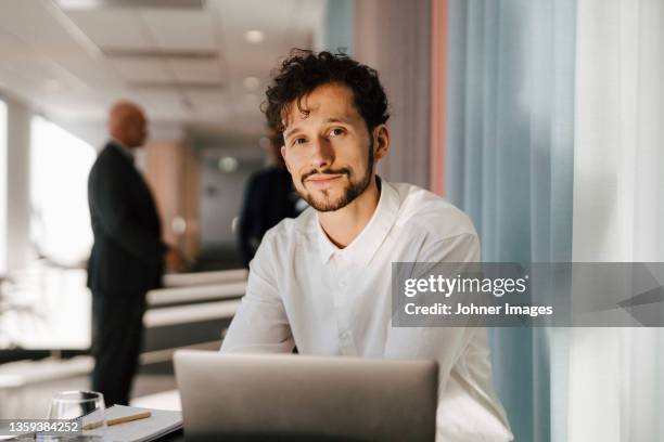 man with laptop sitting in office - mann mitte 30 stock-fotos und bilder