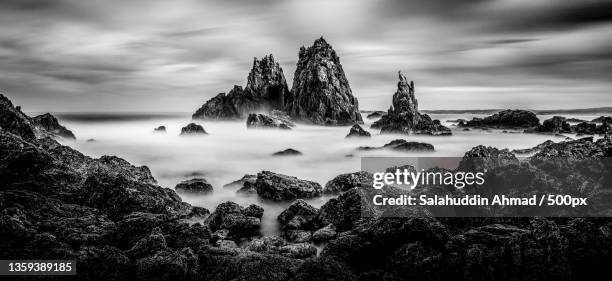 coastal black and white,panoramic view of rocks on beach against sky - landscape black and white stock pictures, royalty-free photos & images