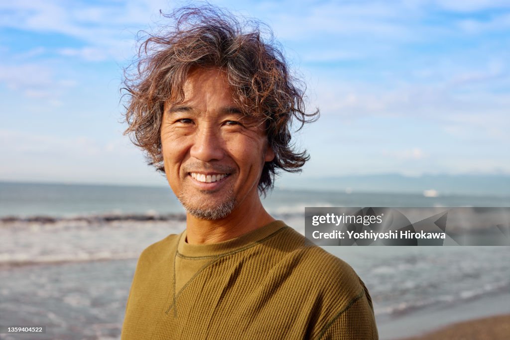 Portrait of genuine surfer man in 50s with smile