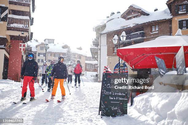 Skiers come back from the slopes after a ski session on December 11, 2021 in Les Arcs, France. French mountain resorts reopen after a 2020 hiatus due...