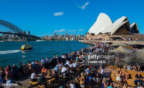 People drinking and eating at the restaurants and bars around the Sydney Opera House, Sydney, Australia.