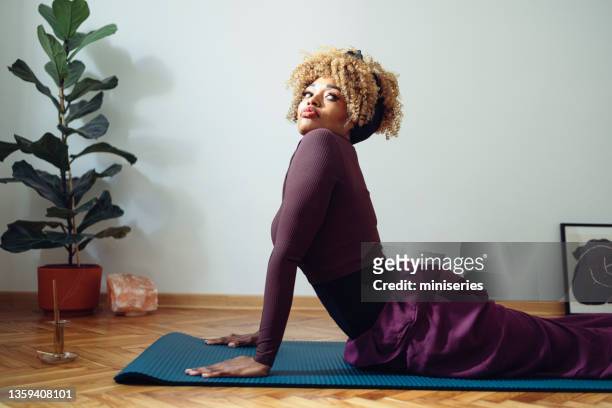 beautiful woman in a cobra pose doing yoga at home - cobra stock pictures, royalty-free photos & images