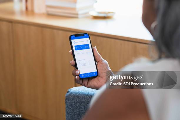 mujer irreconocible usa la aplicación de banca en línea en un teléfono inteligente - cuenta de banco fotografías e imágenes de stock