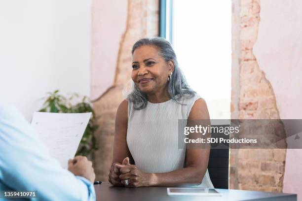 mujer anciana nerviosa espera a que el gerente masculino revise el currículum - curriculum vitae fotografías e imágenes de stock