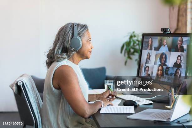 senior ceo leads meeting with employees from home - young businessman using a virtual screen stockfoto's en -beelden