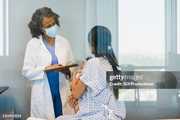 emergency room doctor listens to new mother - er stock pictures, royalty-free photos & images