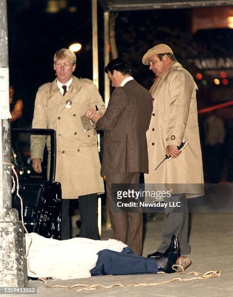 Detectives gather evidence near the body of Paul Castellano, boss of the Gambino crime family, after he was shot and killed outside of Sparks Steak...
