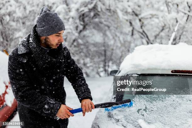 Ein Junger Mann Reinigt Mit Einer Schaufel Schnee Aus Einem Auto
