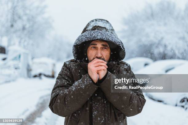 retrato tomado del hombre maduro caucásico de buen aspecto en estilo casual se congela en el frío día de invierno mientras está de pie en el centro de la ciudad. - congelacion fotografías e imágenes de stock