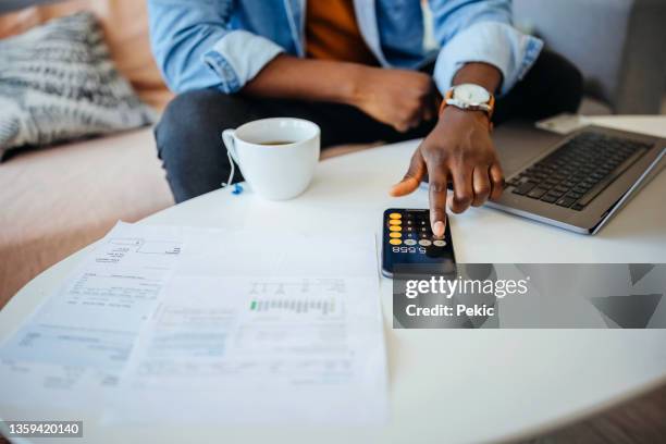 unrecognisable man going over his finances - calculadora imagens e fotografias de stock