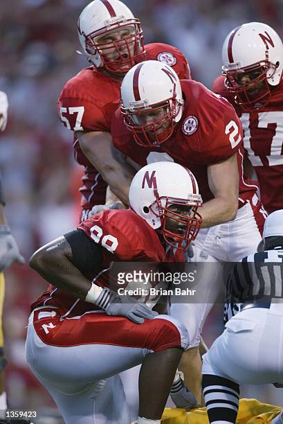 Safety Aaron Terpening of the Nebraska Cornhuskers helps defensive end Demoine Adams to his feet during the NCAA football game against the Arizona...