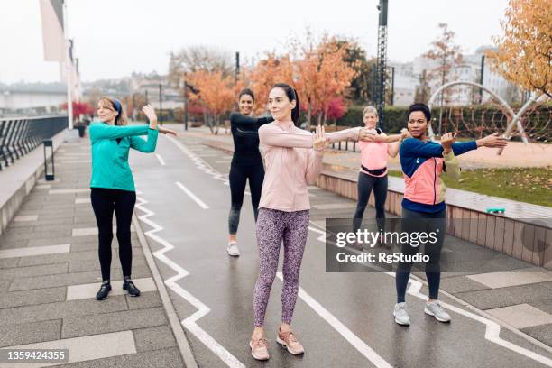 group of women practicing yoga on a rainy day - yoga studio exterior stock pictures, royalty-free photos & images