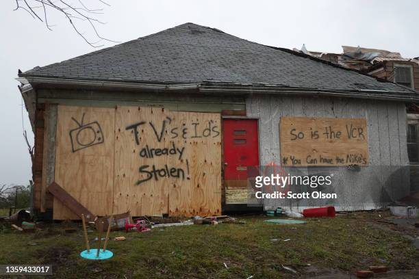 Message to looters is painted on a home damaged during last week's tornado on December 16, 2021 in Dawson Springs, Kentucky. Multiple tornadoes...