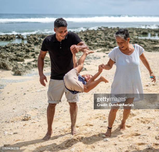 multi generation family playing with child on beach - philippines family stock pictures, royalty-free photos & images