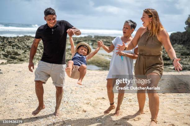 multi generation family playing with child on beach - philippines family imagens e fotografias de stock