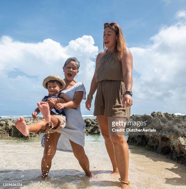 grandmother and mother play with son in the water - philippines family 個照片及圖片檔