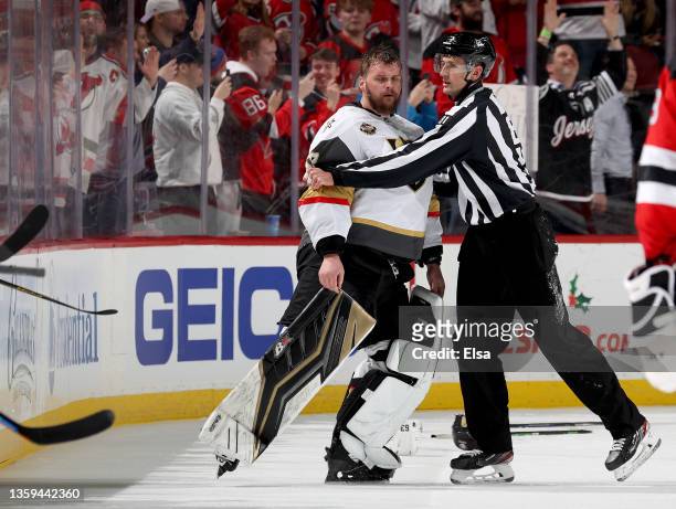 Robin Lehner of the Vegas Golden Knights is escorted off the ice after an altercation with members of the New Jersey Devils during the third period...