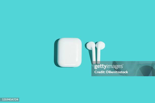 wireless white headphones on turquoise background. - apple white background stock-fotos und bilder